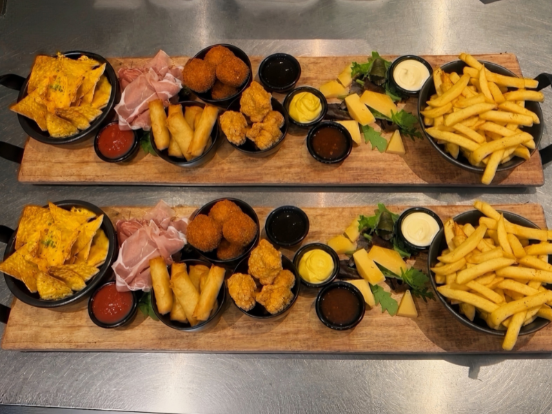 wee rijkgevulde borrelplanken met warme hapjes, kaas, vleeswaren, nacho's, friet en dips.