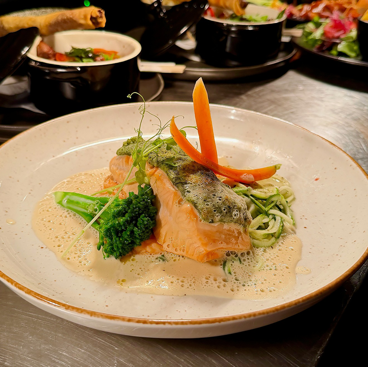 Zalmgerecht met verse groenten en romige saus bij Plateau Eten & Drinken.